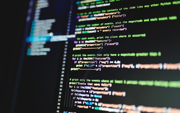 Lines of source code on a dark monitor