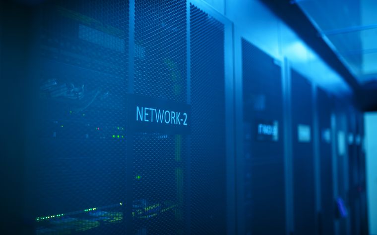 An illuminated blue network rack in a server room
