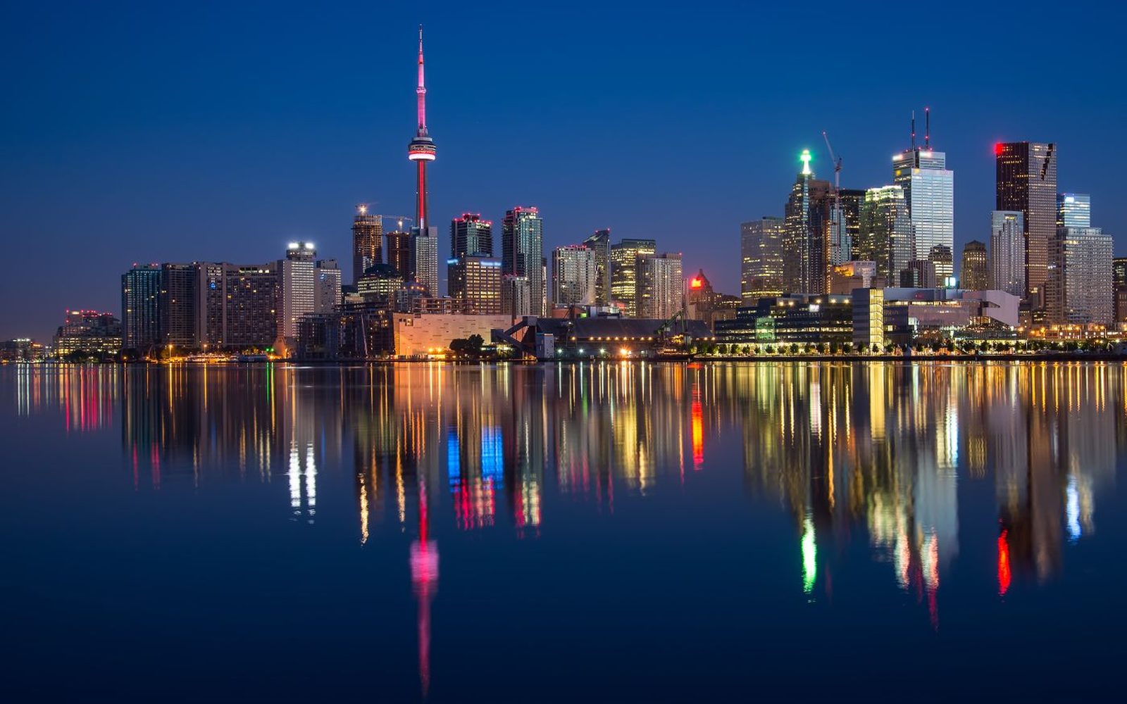 A city skyline reflected in water after dark